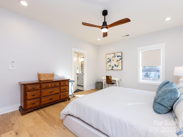 bedroom featuring ceiling fan, light hardwood / wood-style floors, and ensuite bath