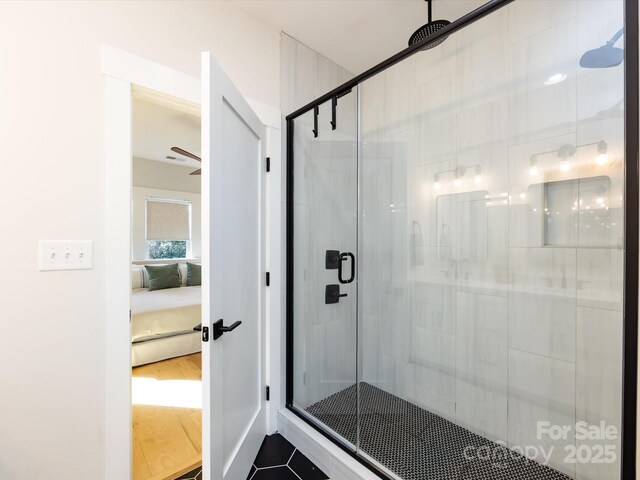 bathroom with ceiling fan, a shower with door, and tile patterned flooring