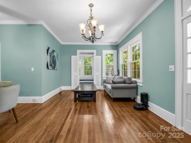 sitting room featuring hardwood / wood-style flooring, crown molding, and a notable chandelier