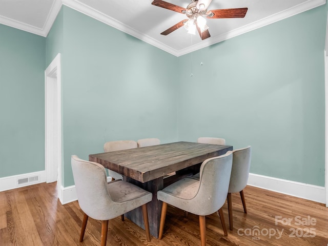 dining space featuring hardwood / wood-style flooring, ceiling fan, and ornamental molding