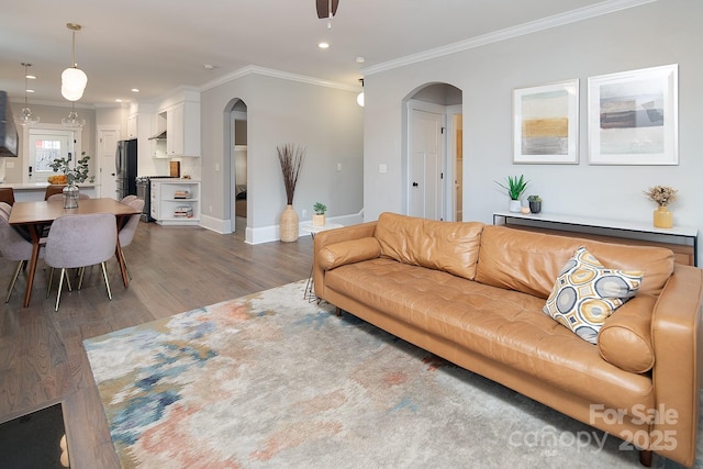 living room with crown molding, ceiling fan, and dark hardwood / wood-style floors