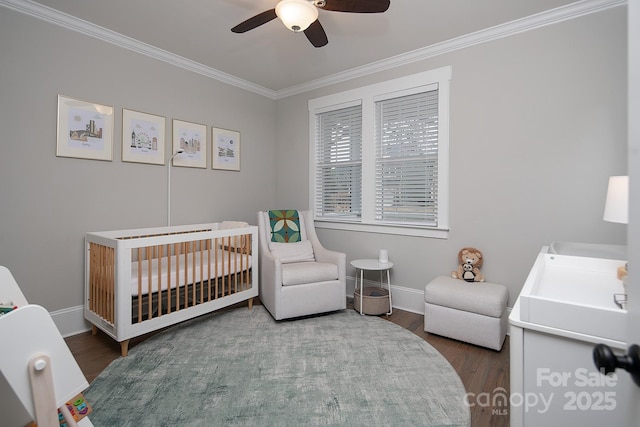 bedroom with wood-type flooring, a nursery area, ornamental molding, and ceiling fan