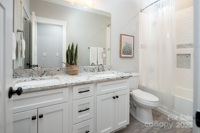 full bathroom with hardwood / wood-style floors, vanity, shower / tub combo, and toilet