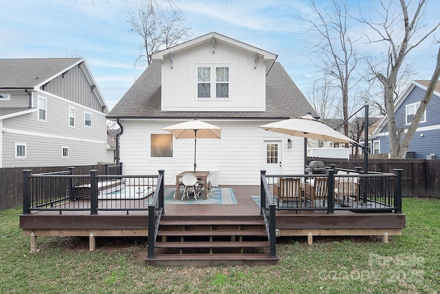 rear view of property featuring a deck and a lawn