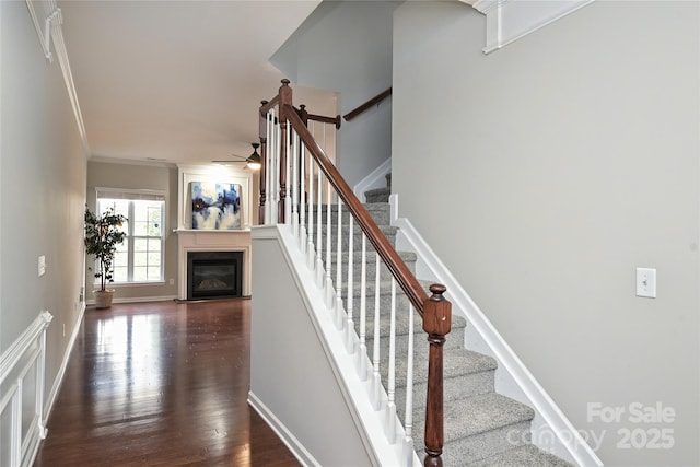 stairs featuring wood-type flooring and ornamental molding