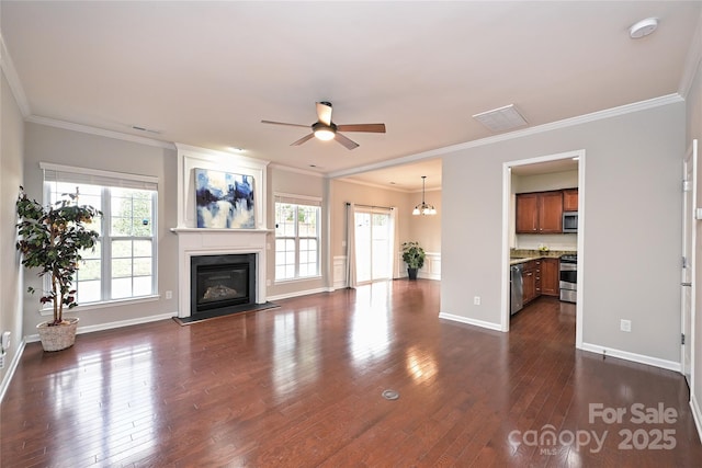 unfurnished living room with dark hardwood / wood-style flooring, ceiling fan with notable chandelier, and ornamental molding