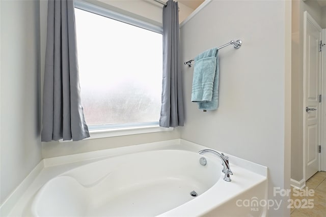 bathroom featuring a tub to relax in, tile patterned floors, and plenty of natural light