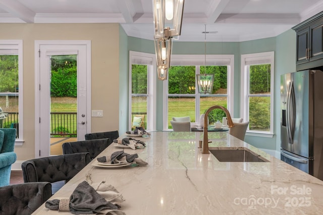 dining area featuring a healthy amount of sunlight, an inviting chandelier, crown molding, sink, and beam ceiling