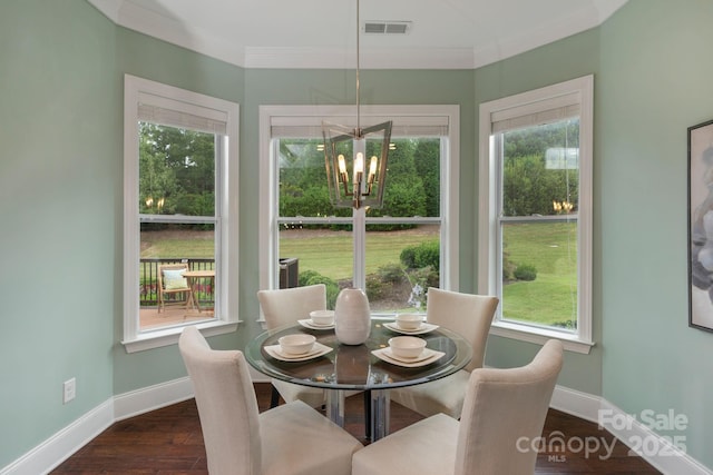 dining space featuring ornamental molding, dark hardwood / wood-style floors, and an inviting chandelier