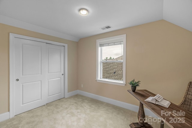 interior space with light carpet, a closet, and lofted ceiling