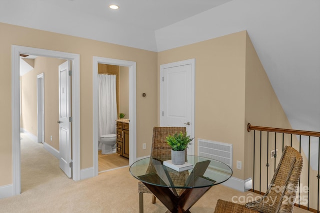 interior space featuring light colored carpet and lofted ceiling