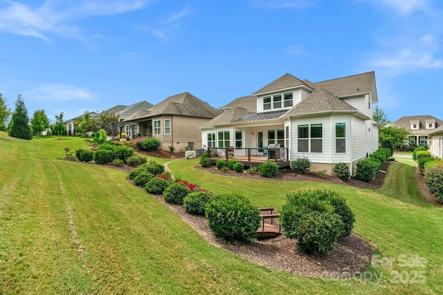 rear view of property with a yard and a wooden deck