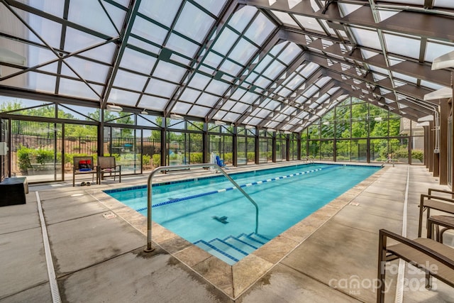 view of pool featuring glass enclosure and a patio area