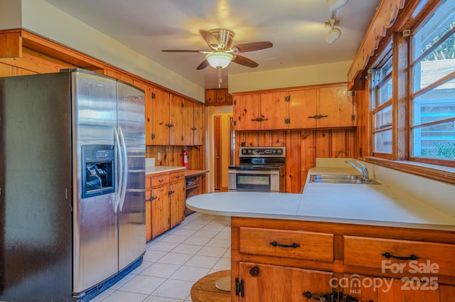 kitchen with stainless steel fridge, stove, ceiling fan, sink, and light tile patterned flooring