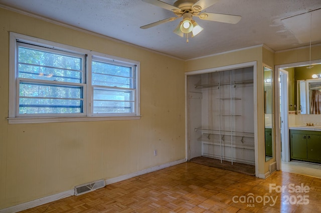 unfurnished bedroom featuring multiple windows, ceiling fan, and light parquet flooring