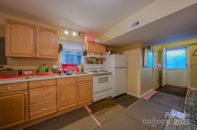 kitchen with light brown cabinets, white appliances, and sink