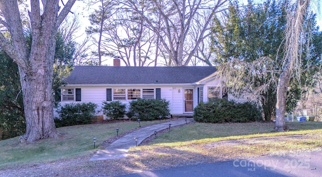 single story home featuring a front lawn