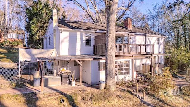 back of property featuring a jacuzzi and a balcony