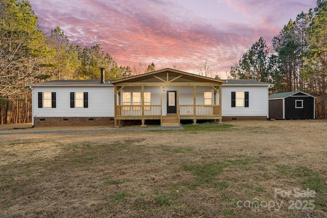 view of front of house with a wooden deck, a yard, and a storage shed