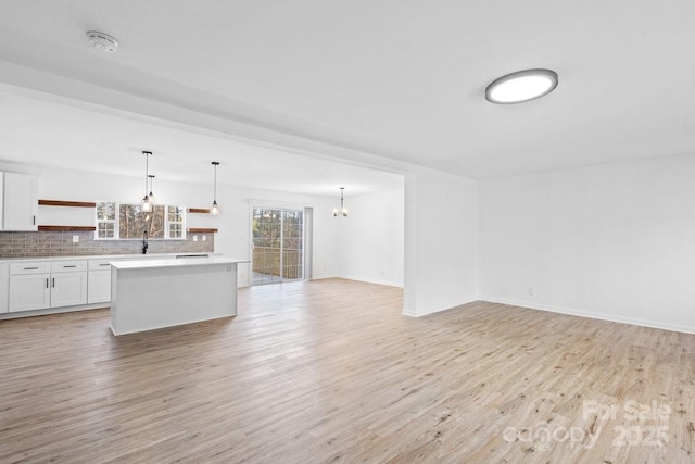 unfurnished living room featuring light wood-type flooring and sink