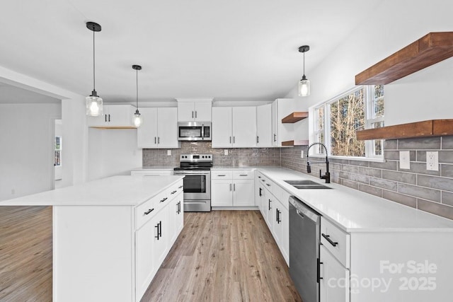 kitchen with appliances with stainless steel finishes, white cabinetry, pendant lighting, and sink