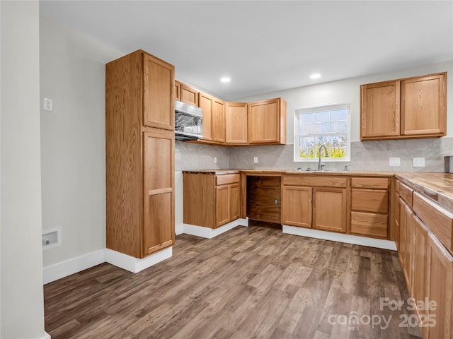 kitchen featuring wood-type flooring, backsplash, and sink