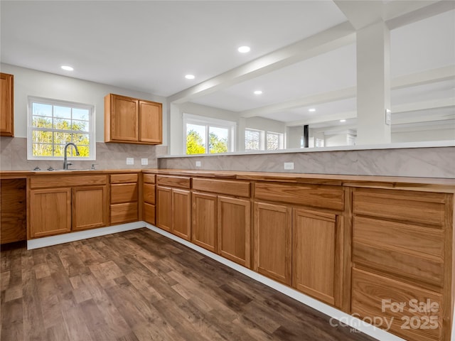 kitchen featuring tasteful backsplash, sink, beamed ceiling, and dark wood-type flooring