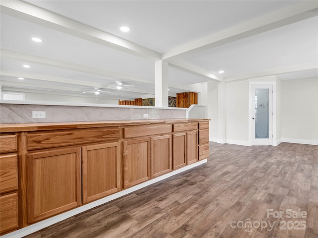 kitchen featuring wood-type flooring, ceiling fan, and beam ceiling