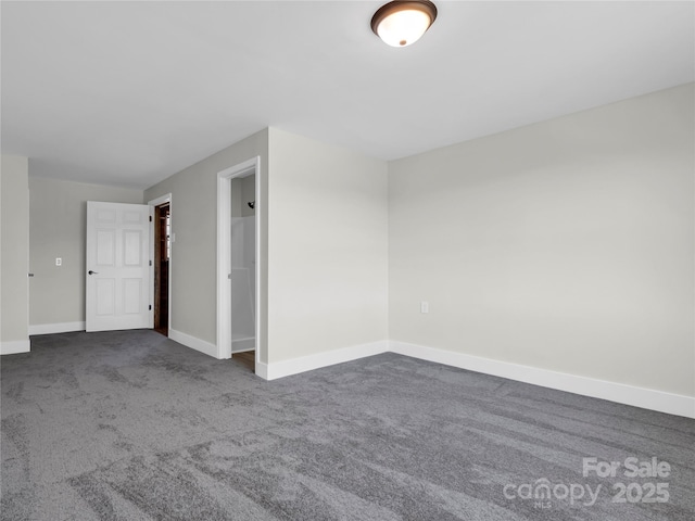 spare room featuring dark carpet