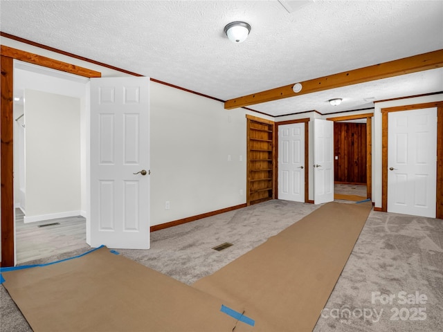 interior space featuring beam ceiling and a textured ceiling