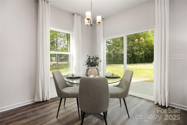 dining area featuring dark hardwood / wood-style flooring, an inviting chandelier, and plenty of natural light