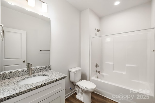 full bathroom with hardwood / wood-style flooring, vanity, toilet, and washtub / shower combination