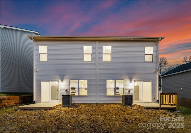 back house at dusk featuring a patio and central air condition unit