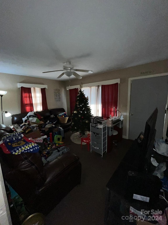 living room with ceiling fan and a textured ceiling