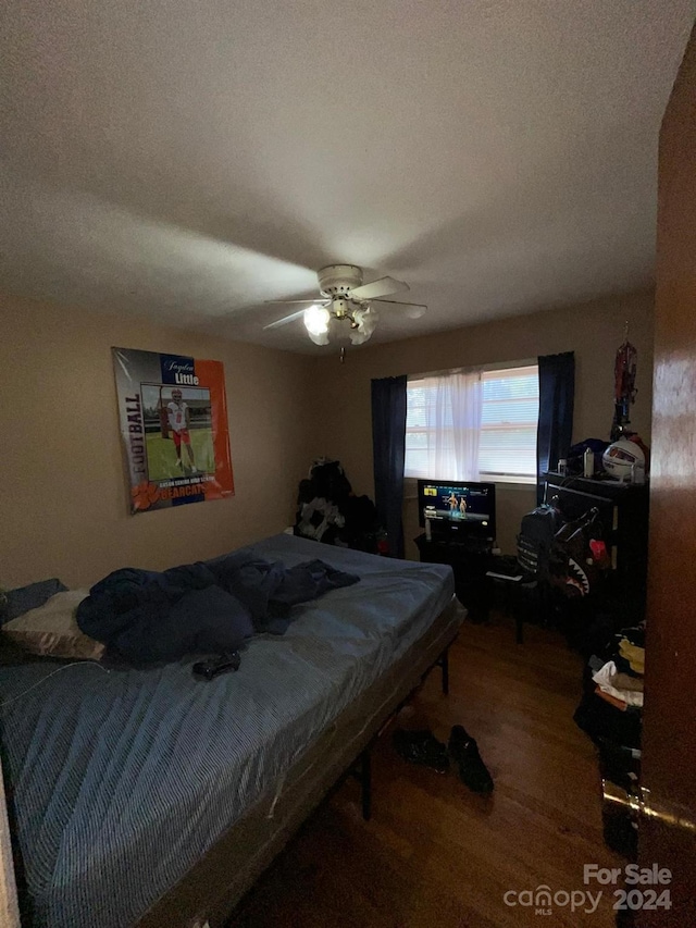 bedroom featuring hardwood / wood-style floors, ceiling fan, a textured ceiling, and pool table