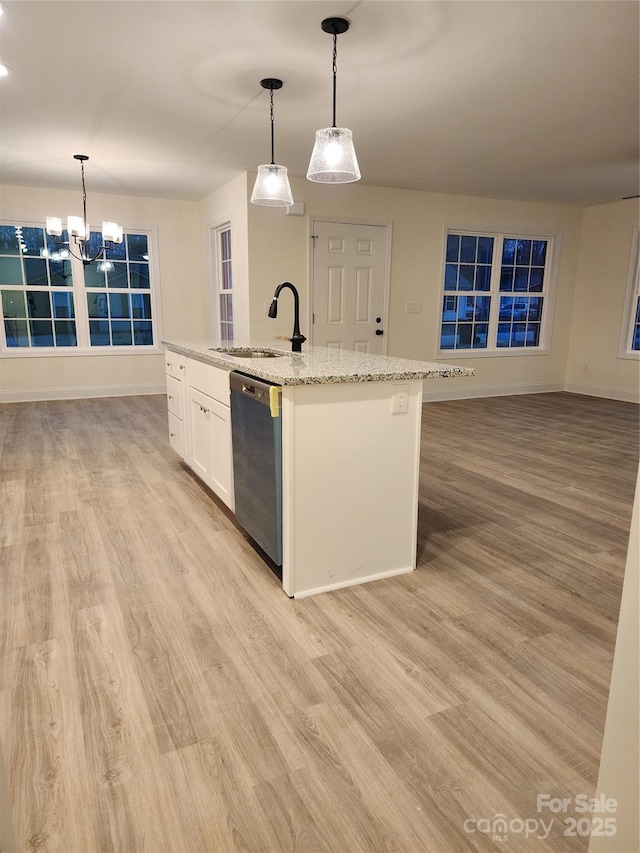 kitchen featuring decorative light fixtures, white cabinetry, sink, a kitchen island with sink, and stainless steel dishwasher