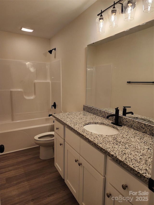 full bathroom with vanity, toilet, hardwood / wood-style floors, and shower / bathing tub combination