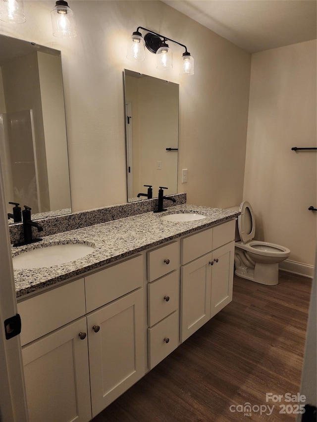 bathroom featuring hardwood / wood-style flooring, toilet, and vanity