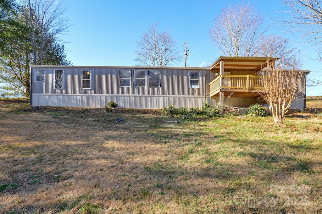 back of house with a deck and a yard