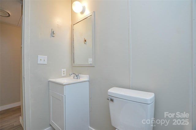 bathroom with toilet, wood-type flooring, and vanity