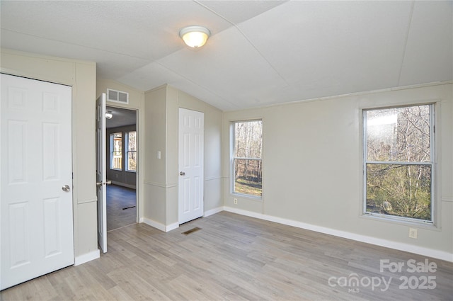 empty room featuring light hardwood / wood-style floors and lofted ceiling