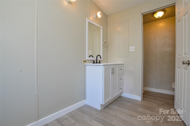 bathroom with wood-type flooring, toilet, and vanity