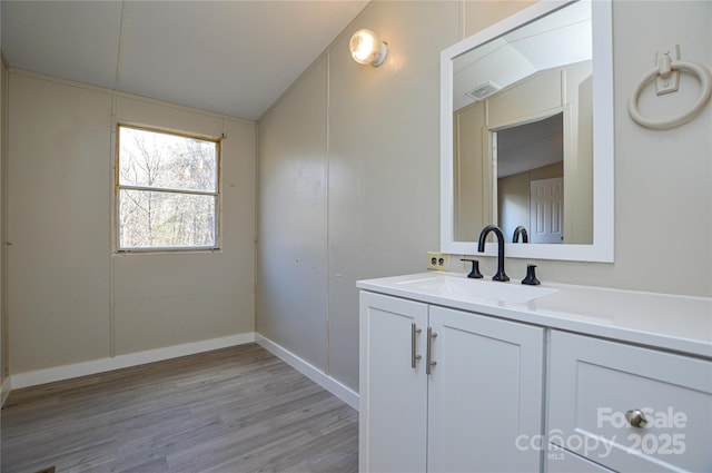 bathroom featuring lofted ceiling, vanity, and wood-type flooring