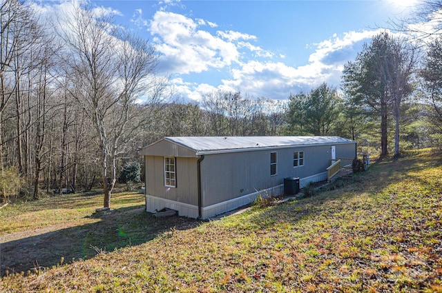 rear view of property with a yard and central AC unit