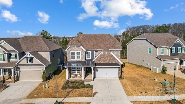 view of front of property featuring a porch, a garage, and a front lawn