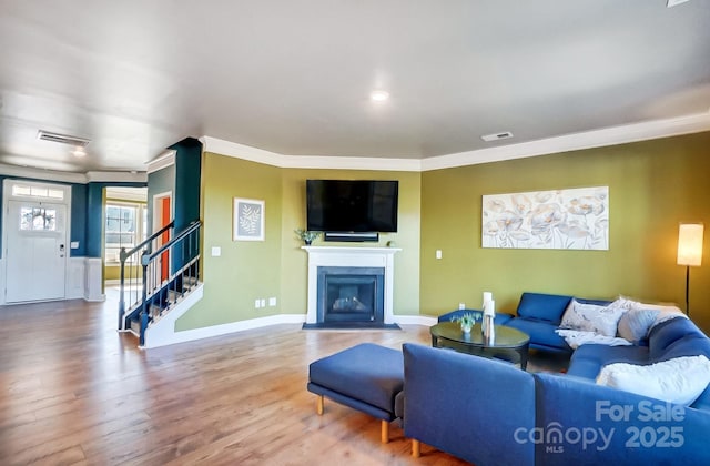 living room featuring hardwood / wood-style flooring and ornamental molding