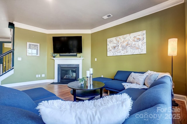 living room with crown molding and hardwood / wood-style floors