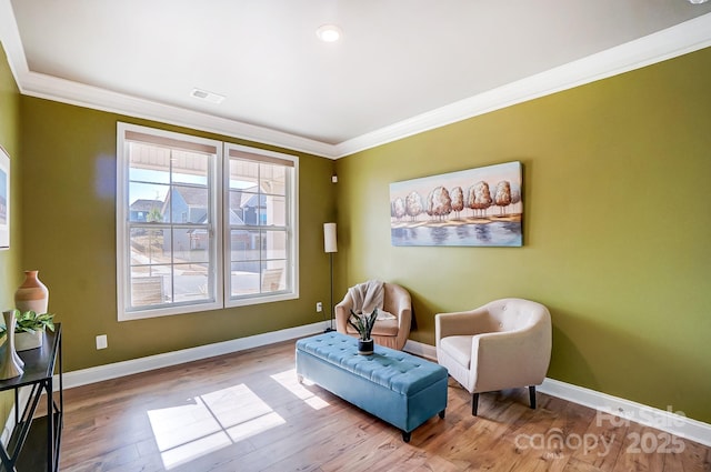 sitting room featuring light wood-type flooring and crown molding