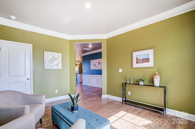 living area with light hardwood / wood-style floors and crown molding