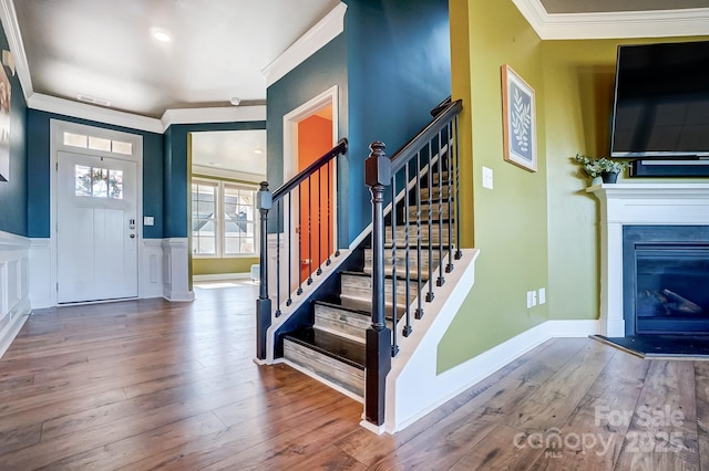 foyer entrance featuring hardwood / wood-style flooring and crown molding